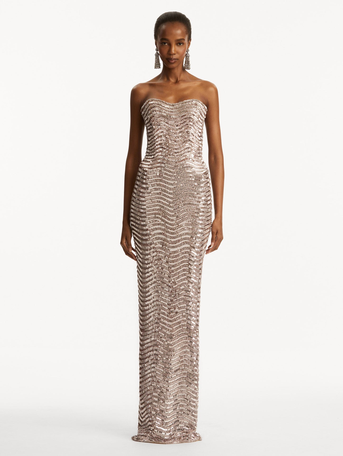 Model wearing soft pink strapless sequin wave embellished gown. Front view