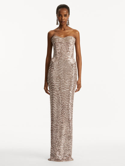 Model wearing soft pink strapless sequin wave embellished gown. Front view
