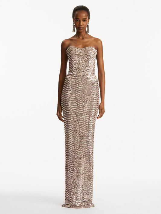 Model wearing soft pink strapless sequin wave embellished gown. Front view