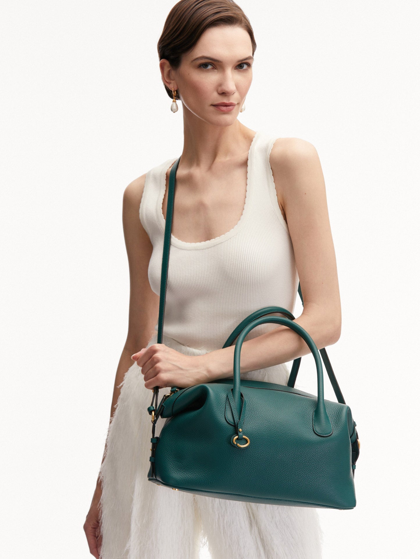 Model Holding the Dahlia Leather Handbag in Green with Detachable Shoulder Strap and O logo tag around the Top Handle. Front View