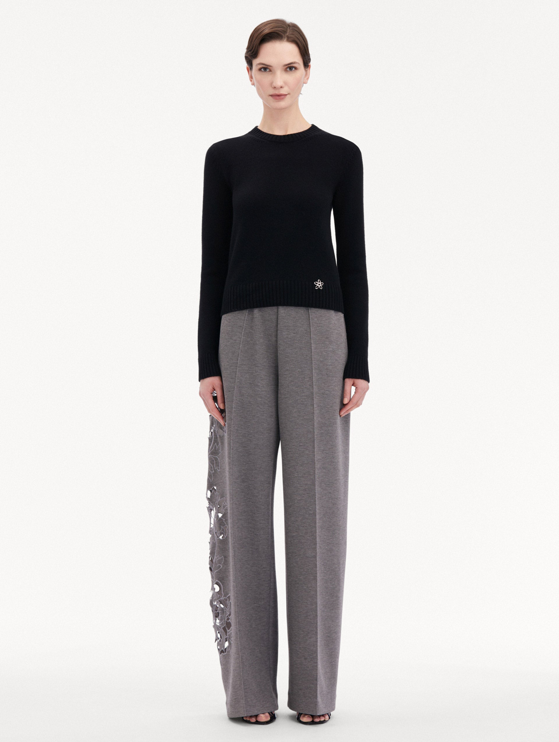 Black O Flower Cashmere Pullover Paired with Grey Trousers Front View