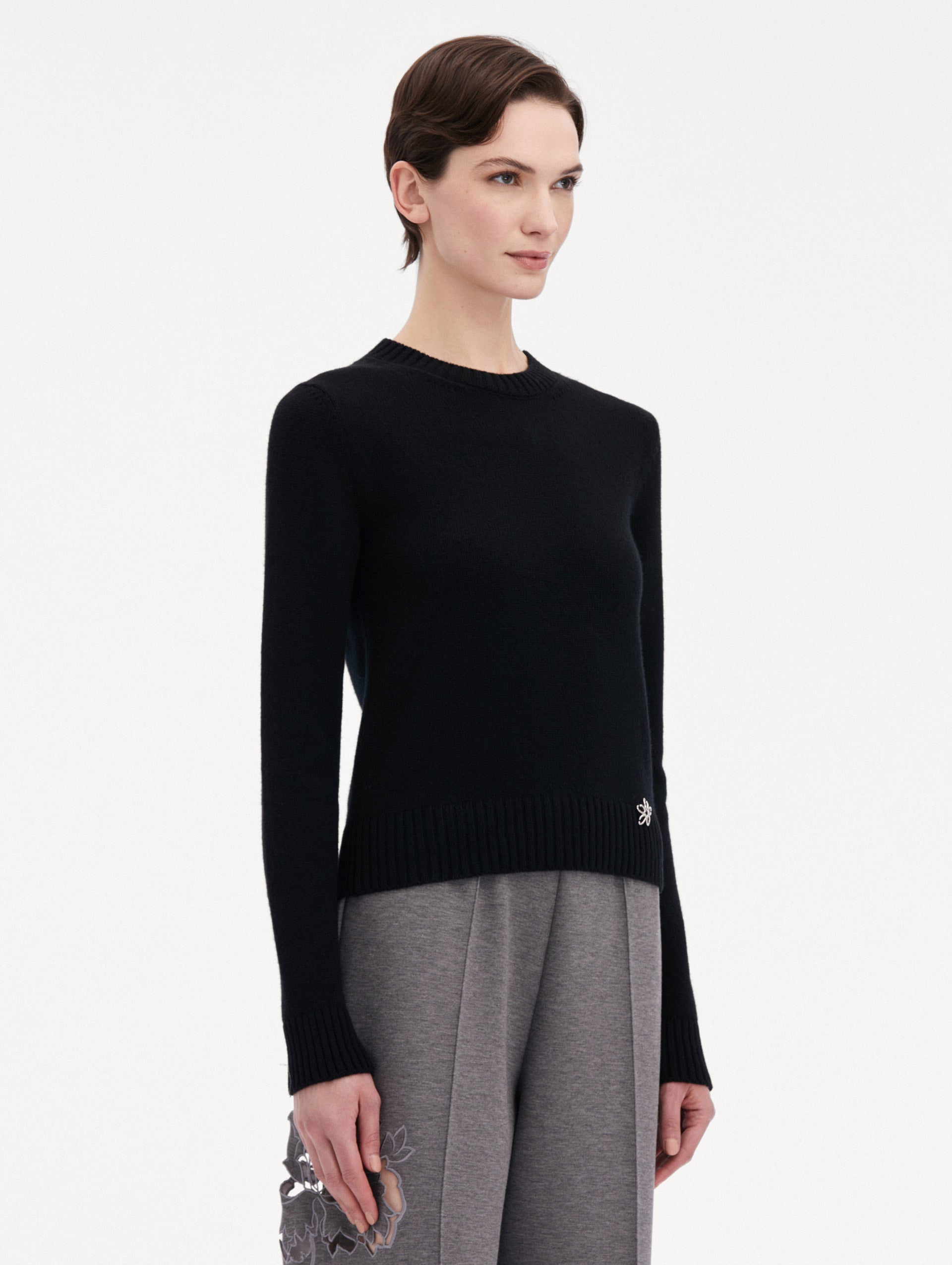 Black O Flower Cashmere Pullover Paired with Grey Trousers Side View