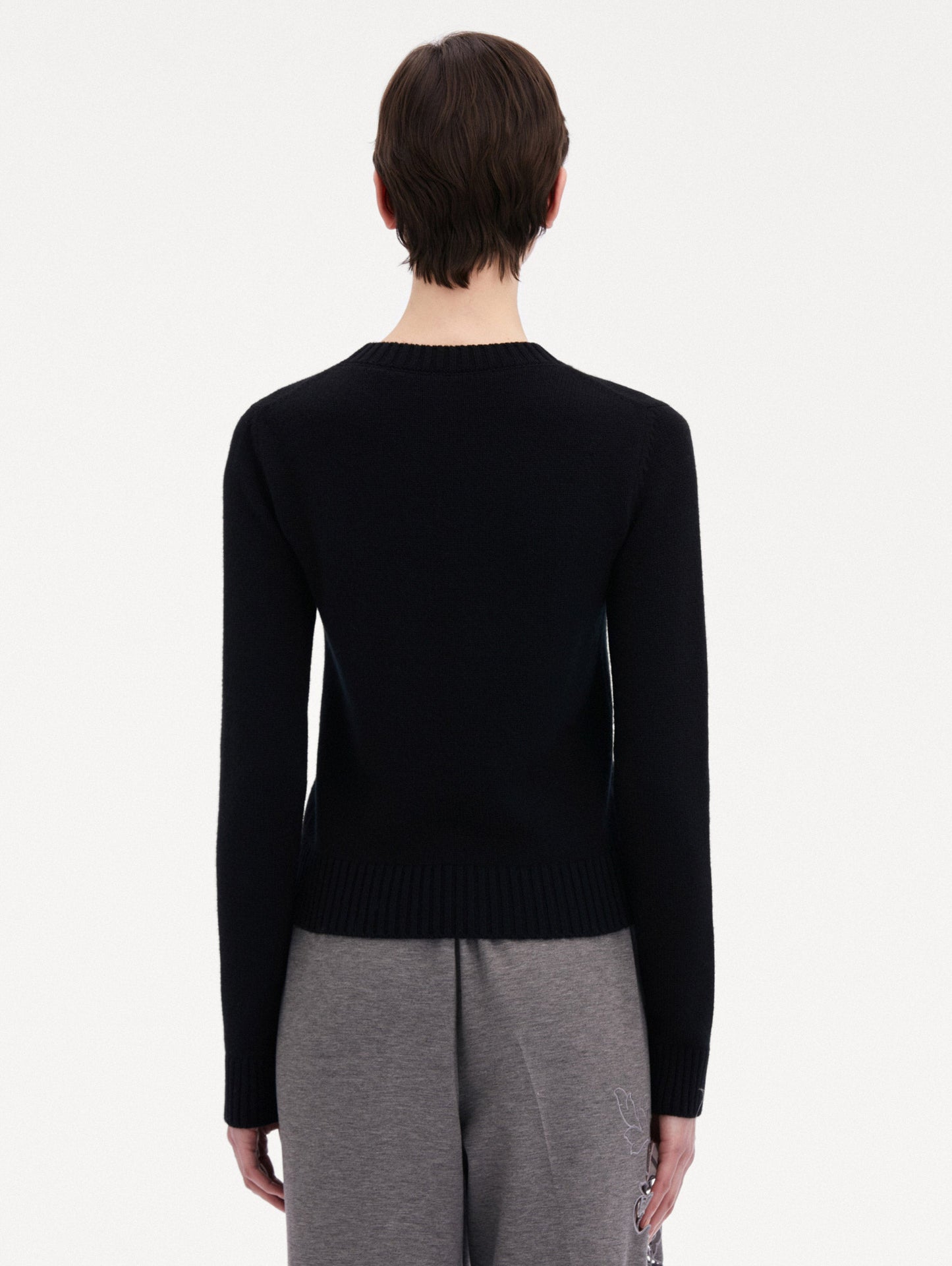Black O Flower Cashmere Pullover Paired with Grey Trousers Back View