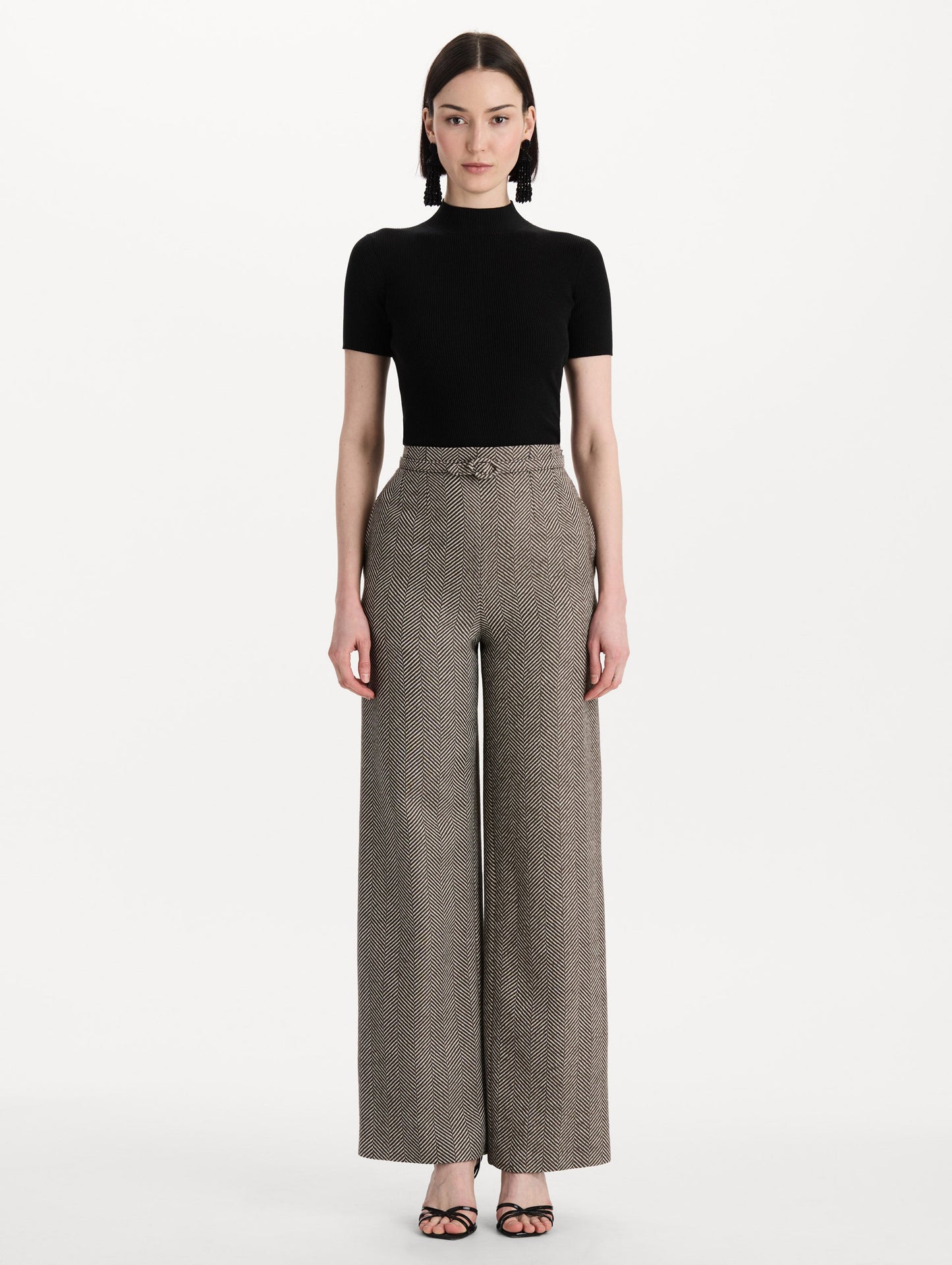 The model is wearing the Chevron Cashmere-Blend Pant featuring a high waist, pockets, and coordinating belt. Front View.