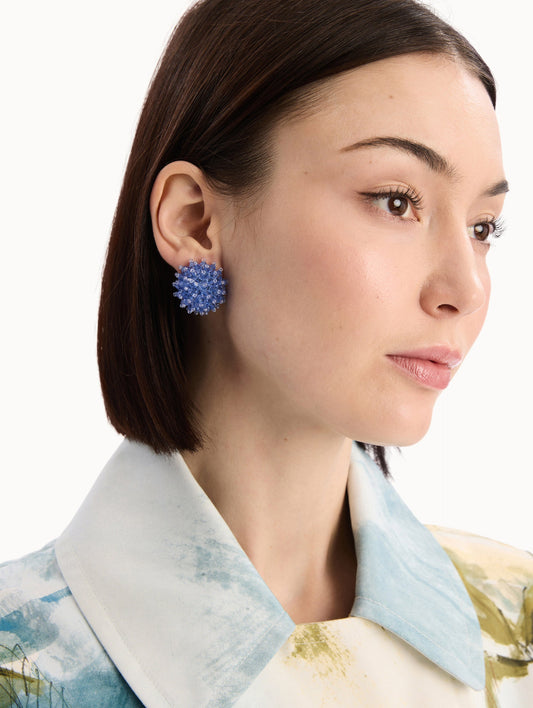 The model is wearing the Beaded Cluster Earrings in Sapphire Blue. Detail View.