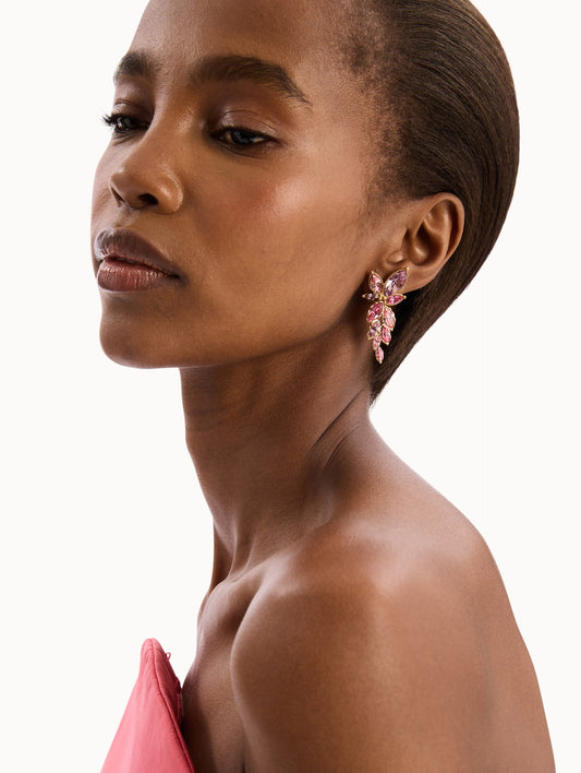 The model is wearing The Navette Crystal Drop Clip-On Earrings in Rose. Detail View.