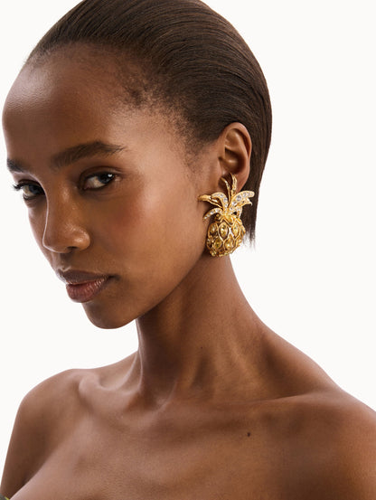 The model is wearing the Pineapple Pavé Clip-On Earrings in Citrine. Detail View.