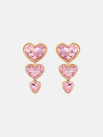 The Crystal Heart Drop Clip-On Earrings in Pink. Three vertically connected hearts with gold rims. Front View.