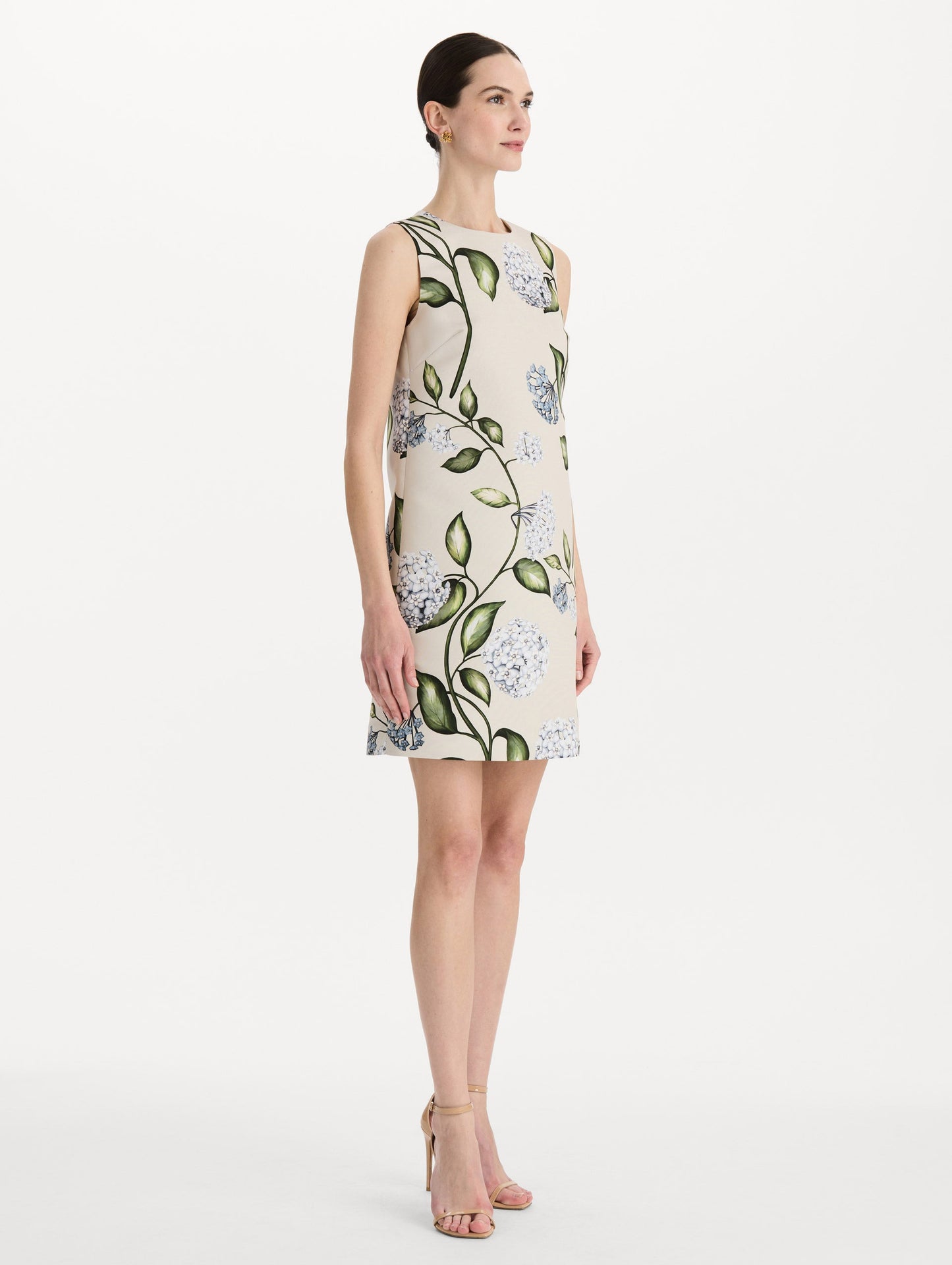 The model is wearing the Porcelain Flower Faille Shift Dress in white featuring a mini-length and printed floral motif. Side View.