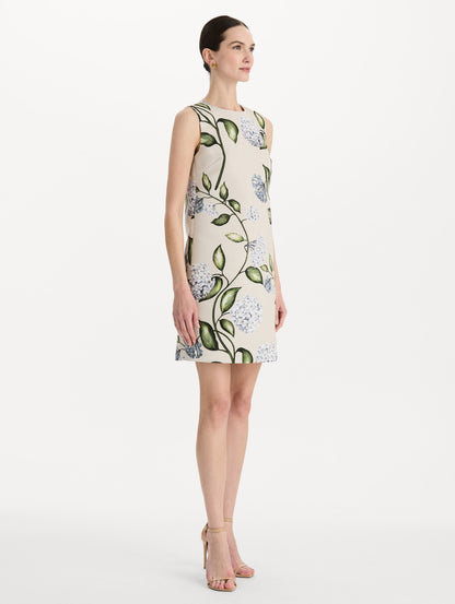 The model is wearing the Porcelain Flower Faille Shift Dress in white featuring a mini-length and printed floral motif. Side View.