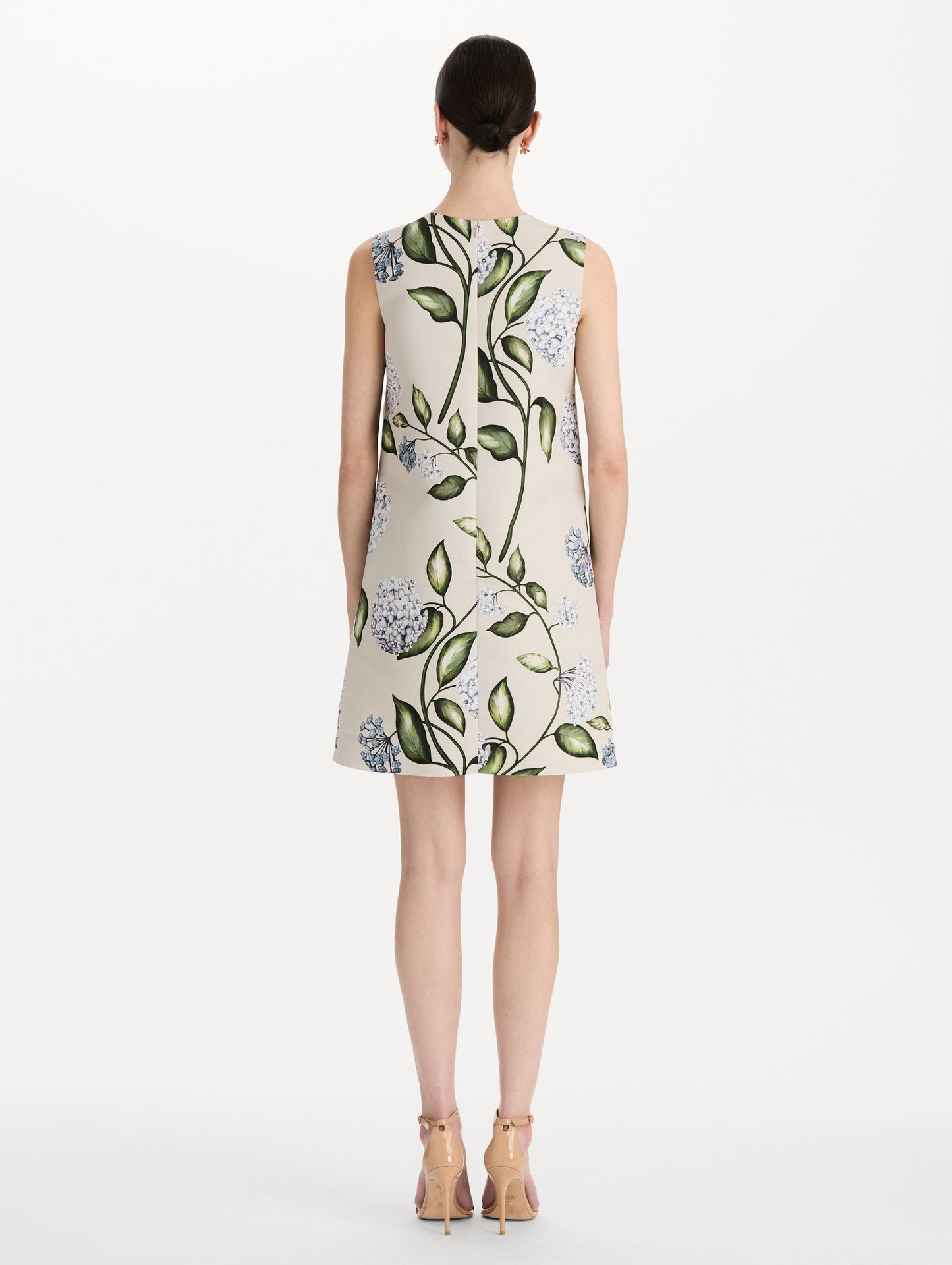 The model is wearing the Porcelain Flower Faille Shift Dress in white featuring a mini-length and printed floral motif. Back View.