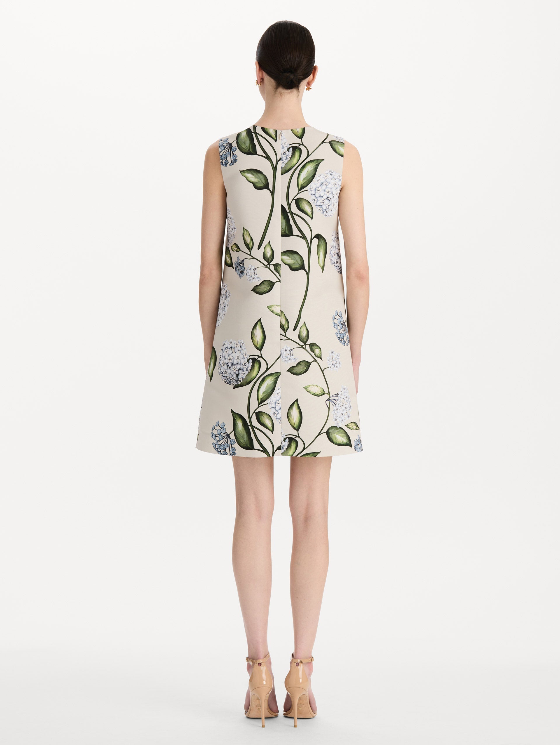 The model is wearing the Porcelain Flower Faille Shift Dress in white featuring a mini-length and printed floral motif. Back View.