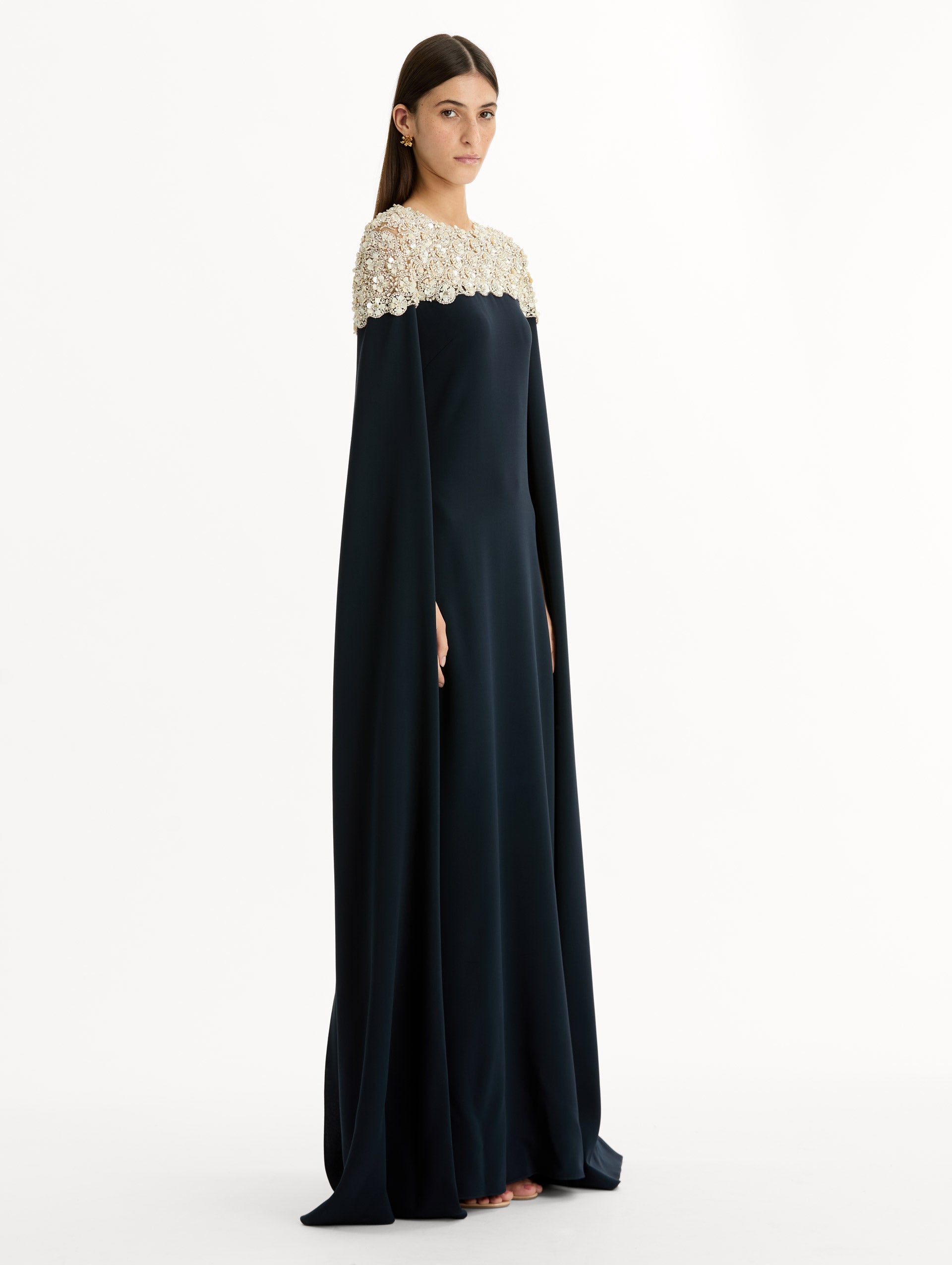 Navy Embroidered Caftan with ivory embroidered neckline and floor-length draped silhouette. Side View.