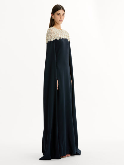 Navy Embroidered Caftan with ivory embroidered neckline and floor-length draped silhouette. Side View.