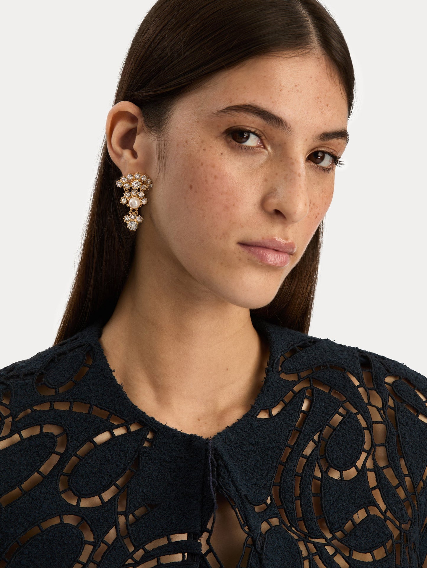 Gold Faceted Crystal Arch Drop Earrings featuring clustered round crystals with central pearl accents. Front View.