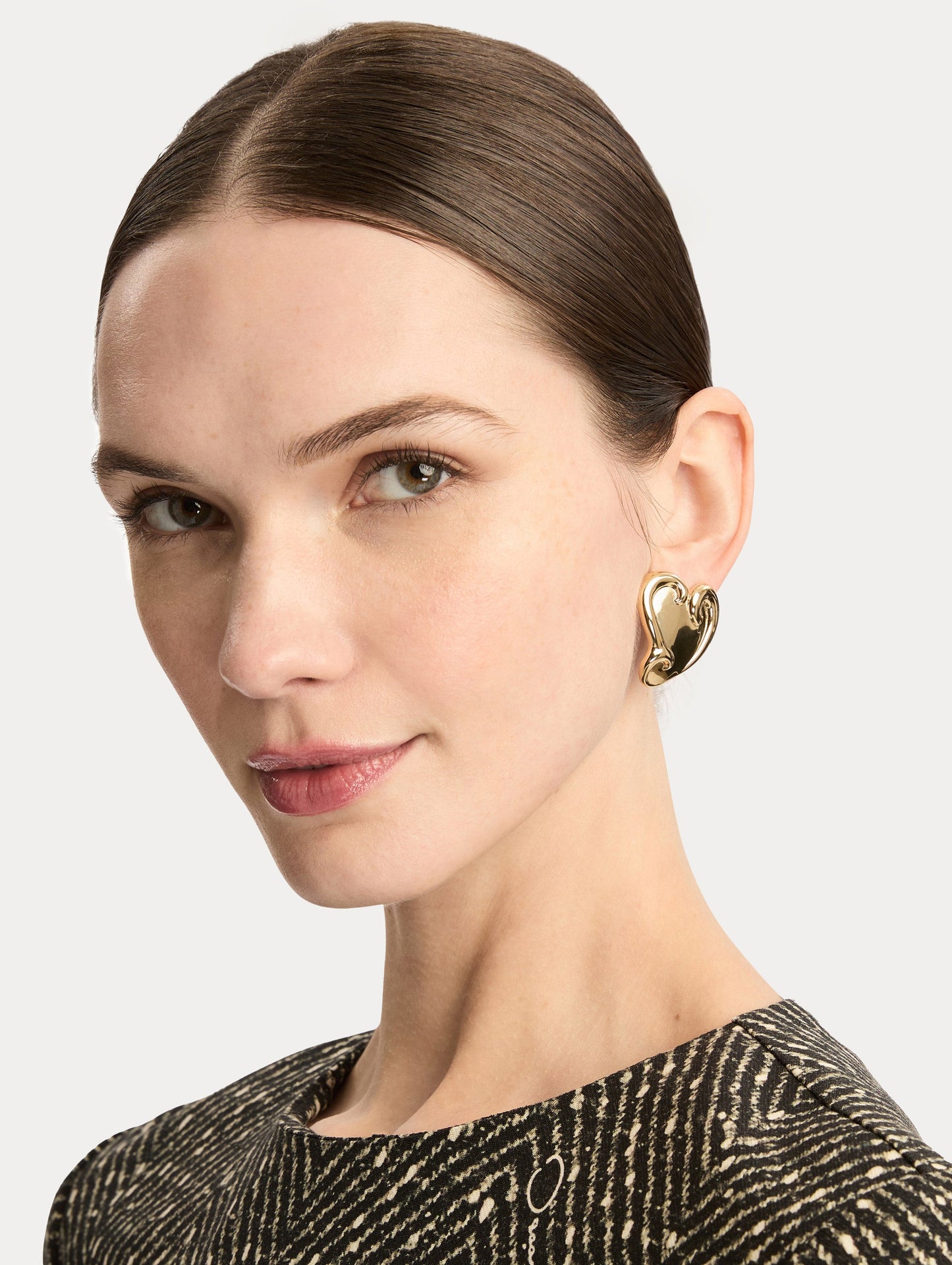 Gold Swirl Heart Clip-On Earrings with sculpted swirl detailing. Side View.