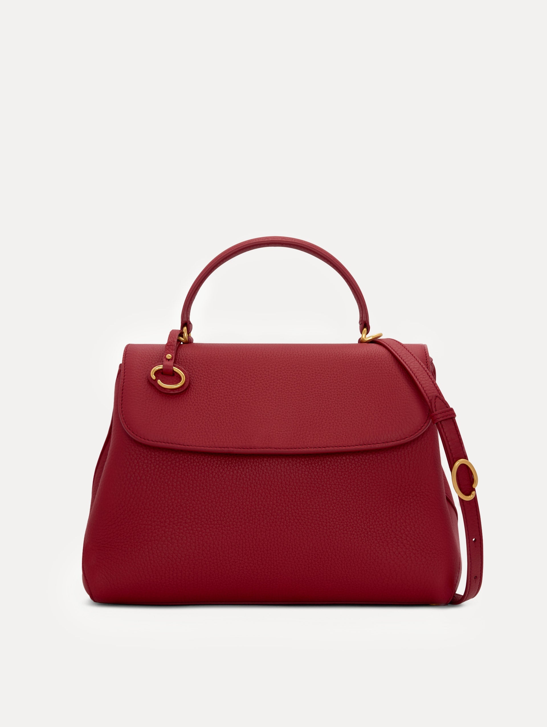 Model in plaid dress wearing The Poppy leather handbag in red with O logo around the top handle. Front View