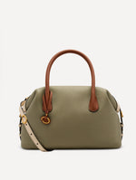Light green bag, with cognac handle, white crossbody strap, and gold Oscar logo in the handle. Front View.